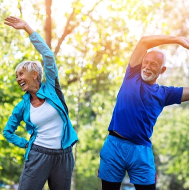 couple wearing exercise clothes and stretching in a park