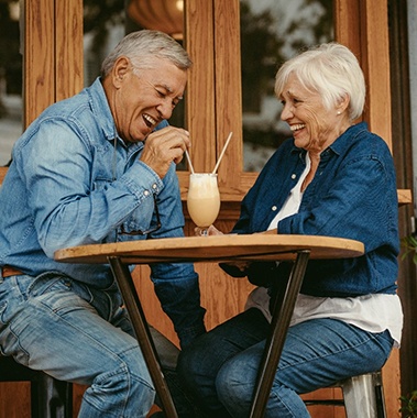Senior couple with dentures in Avon sharing milkshake