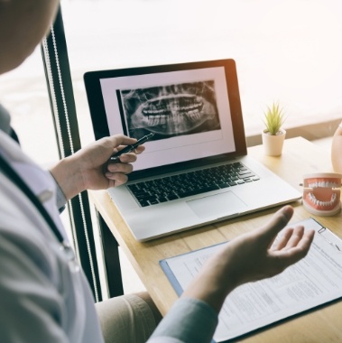 Dentist and patient looking at digital x-rays during dental implant treatment planning