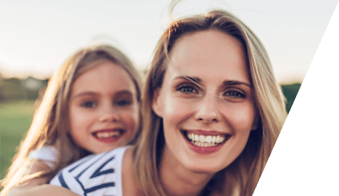 Mother and daughter with healthy smile after children's dentistry