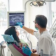 Dentist and patient looking at digital dental x-rays