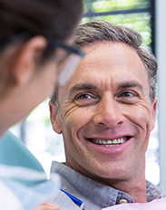 Man in dental chair smiling at dentist