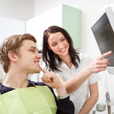 Dental team member and patient looking at computer screen