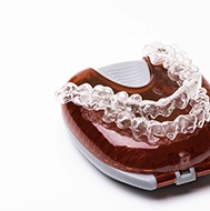 Pair of aligners from Invisalign in Avon resting on a case