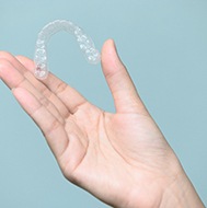 Person holding aligner from Invisalign in Avon