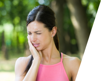 Woman in need of emergency dentistry holding cheek