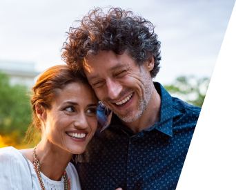 Man and woman smiling after replacing missing teeth