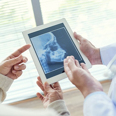 Dentists examining x-rays of the jaw and skull