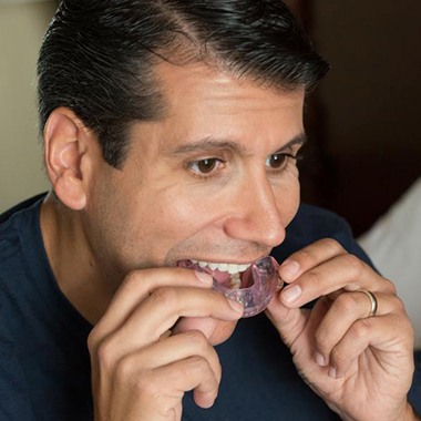 Man taking sleep apnea oral appliance