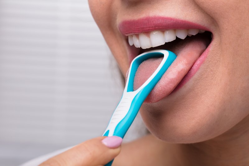 young woman cleaning tongue