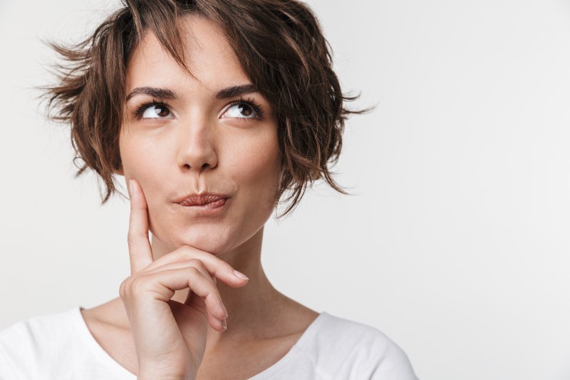 woman thinking veneers or crowns