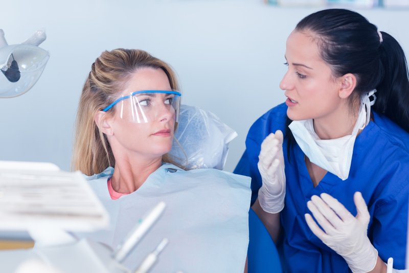 person with lost dental crown talking to dentist